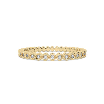Gold ring with round diamonds on a yellow background