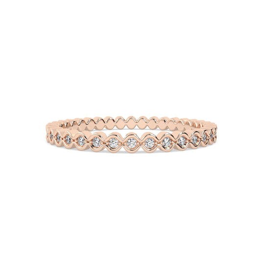 Gold ring with round diamonds on a pink background